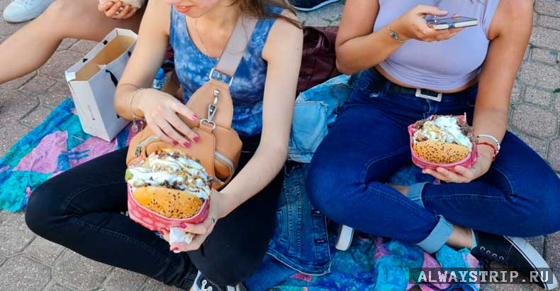 Девушки держат гамбургер